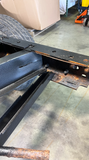 Professional installing the rear spare tire crossmember support piece for improved structural integrity.